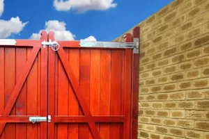 Gate fixed to an adjacent wall